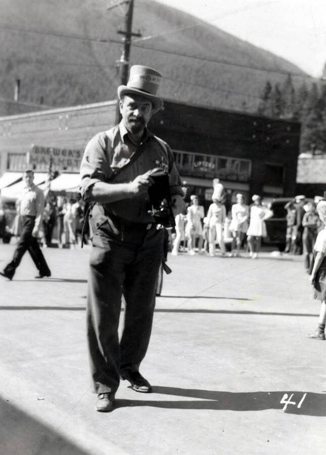 A man holding a camera during the 49'er Parade in Mullan, Idaho.