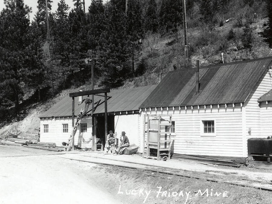 Two men sitting in front of a building at Lucky Friday Mine in Mullan, Idaho.