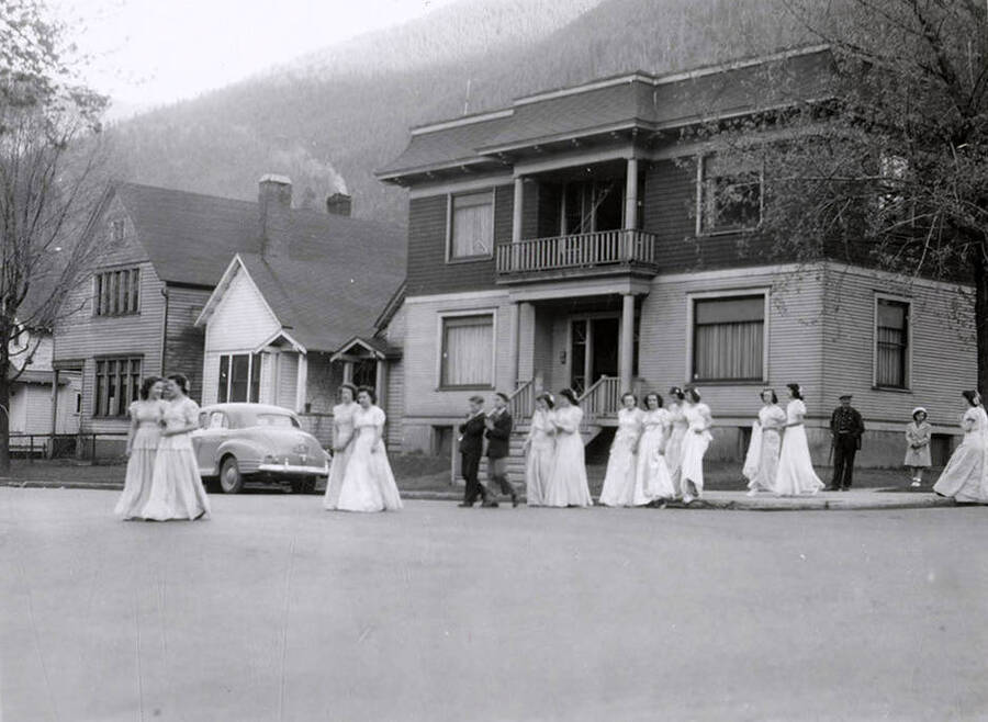 Children walking in pairs across the road outside of Our Lady of Lourdes Academy during the Blessed Virgin Procession in Wallace, Idaho.