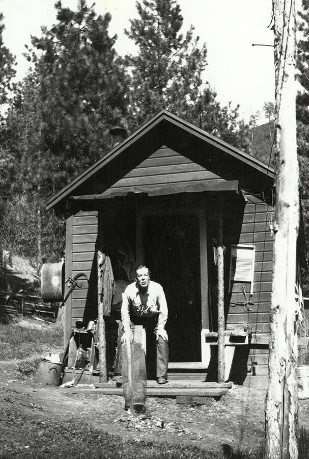 A man standing in the doorway of Tobs cabin near Wallace, Idaho.