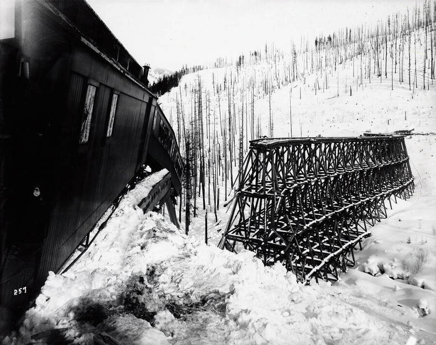 Close-up view of a dangling passenger car. The rear engine and caboose lie out of view, at the bottom of the gulch after a snow slide took out the lower portion of the "S" bridge trestle.