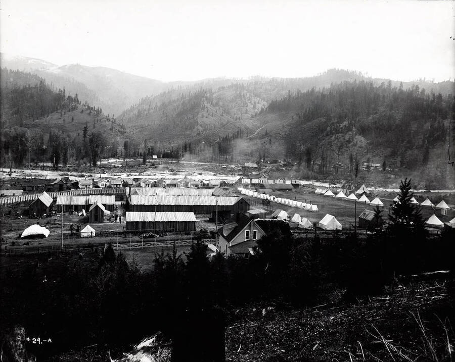 A distant view of the Bull Pen in Kellogg, Idaho; Tents and wooden buildings are pictured. General view (first negative).
