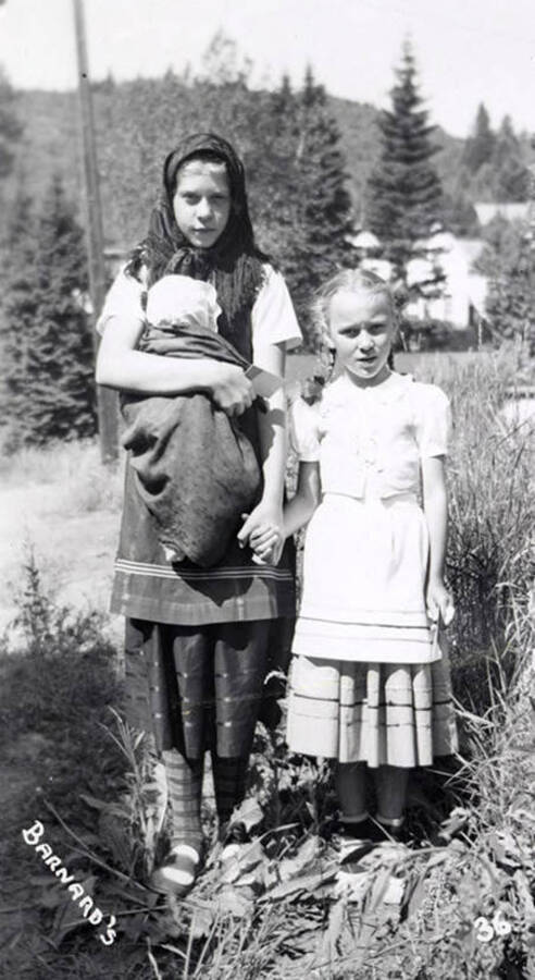 Two girls, and one child being held, in costume for the Mullan 49'er parade in Mullan, Idaho.