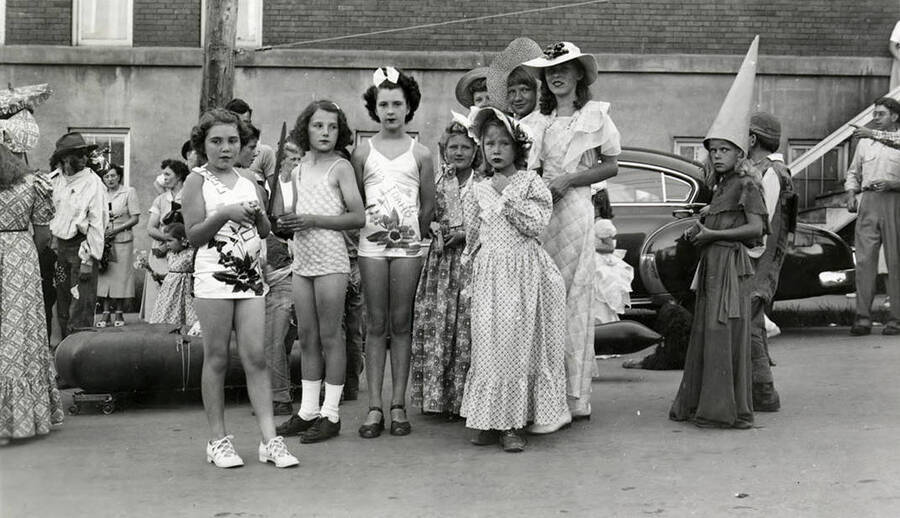 A group of young girls in costumes posing together during the 49'er Parade in Mullan, Idaho.