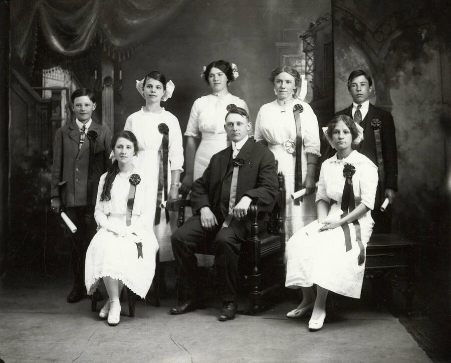 Group photo of the graduating class of 1912 from Gem Public School in Gem Idaho. All students can be seen holding diplomas and wearing ribbons.