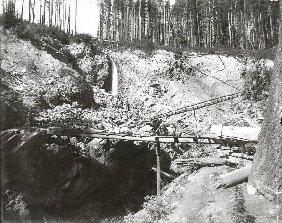 North side, Coeur d'Alene Mining District (Murray area). The flume is in the background, and ladders are strategically placed to get in and out of the placer and across waterways.