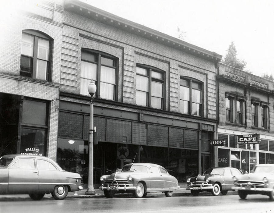 Exterior view of the Independent Order of Odd Fellows (IOOF) Hall inWallace, Idaho. Cars can be seen parked along the street outside the hall.