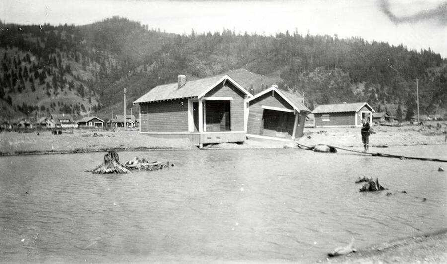 The Sunnyside Addition in Kellogg, Idaho during the flood of 1933. A man can be seen standing on a make-shift bridge outside a house.