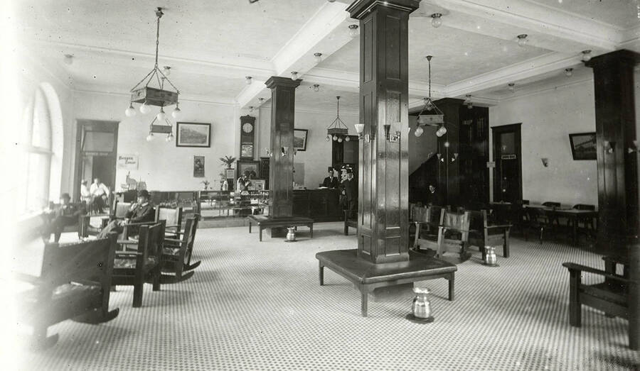 Interior view of Samuels Hotel in Wallace, Idaho. People can be seen sitting around in the hotel.