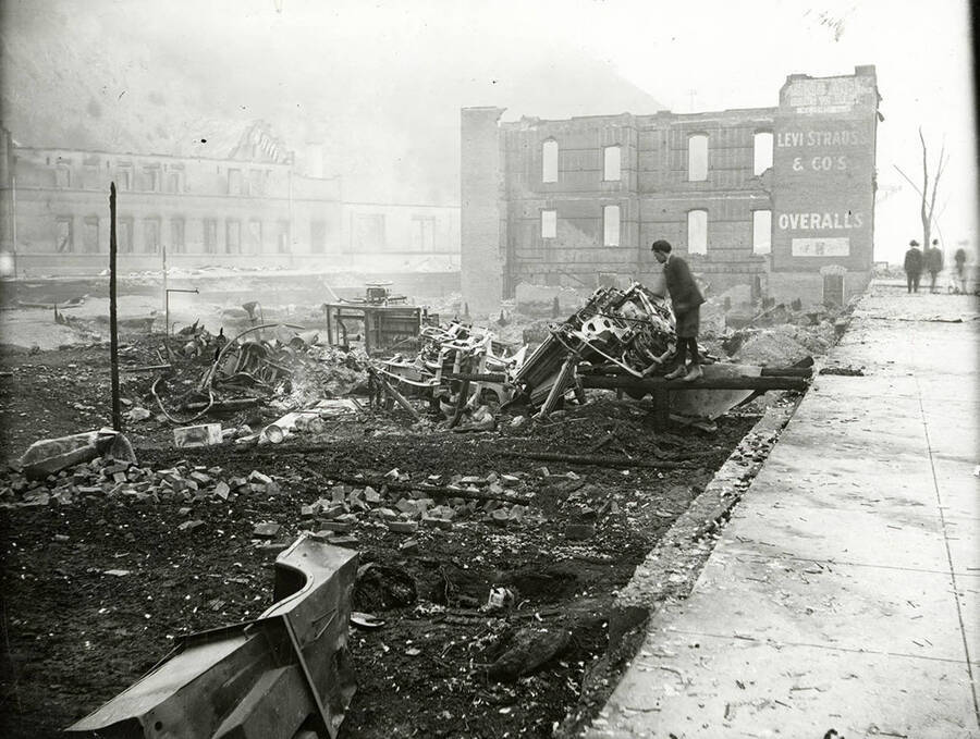 The remains of a brick building at 721 Bank Street in Wallace, Idaho after the "Big Burn" fire of 1910. The OR&N depot can be seen in the background.