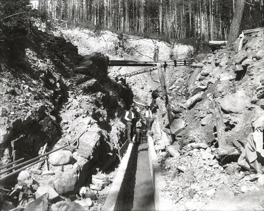 North side, Coeur d'Alene Mining District (Murray area). Water in the flume is flowing towards the photographer.