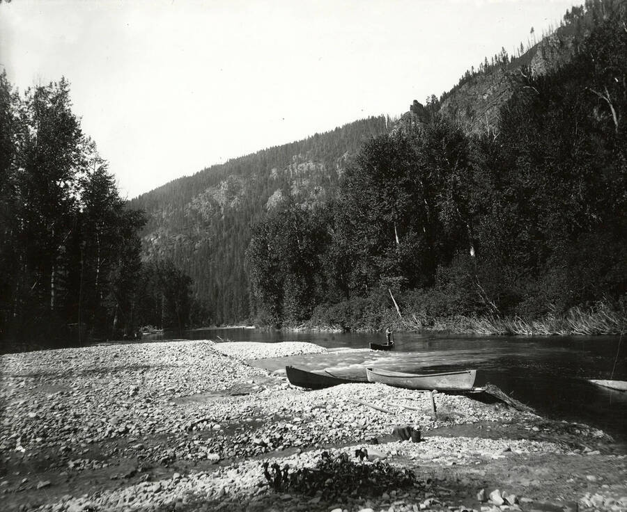 View of a man on a canoe at the mouth of Prichard Creek, near North Fork by the Coeur d'Alene Mining District.