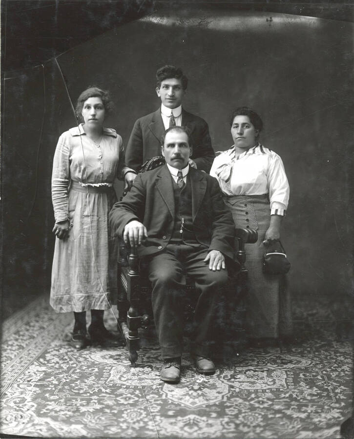 A formal portrait of Joe Fusi and his family. Printed from a cracked glass negative.