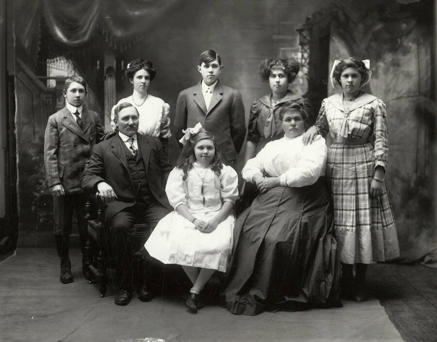Group photo of the Johnson family. A man and woman are seated with a girl, while two boys and three girls stand behind them. Oscar Johnson is pictured in this photo.