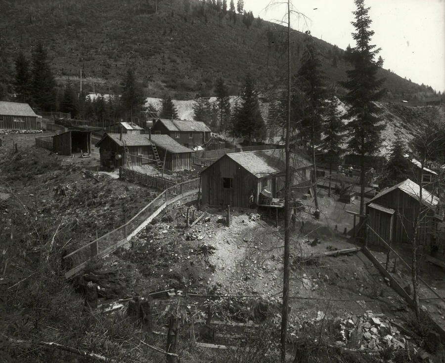 View of an unidentified area showing houses, a railroad bridge, outhouses, and a mill. The photo was taken for Mr. Strode, the proprietor of Mullan Water Company.