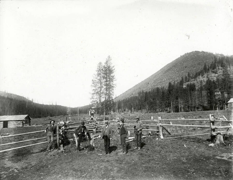 A group of men standing next to a rail fence at Eagle, Idaho. Included in this group are Old Man Robinson, Glum Lum Ferguson, and Coal Oil Johnnie.