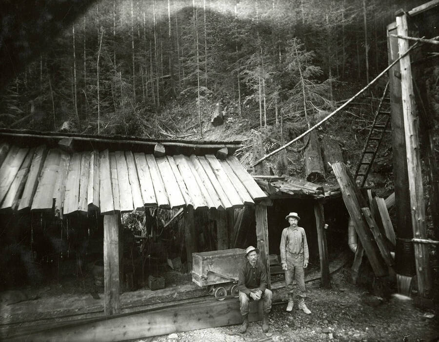 Two men standing in front of a building on an unidentified mine.