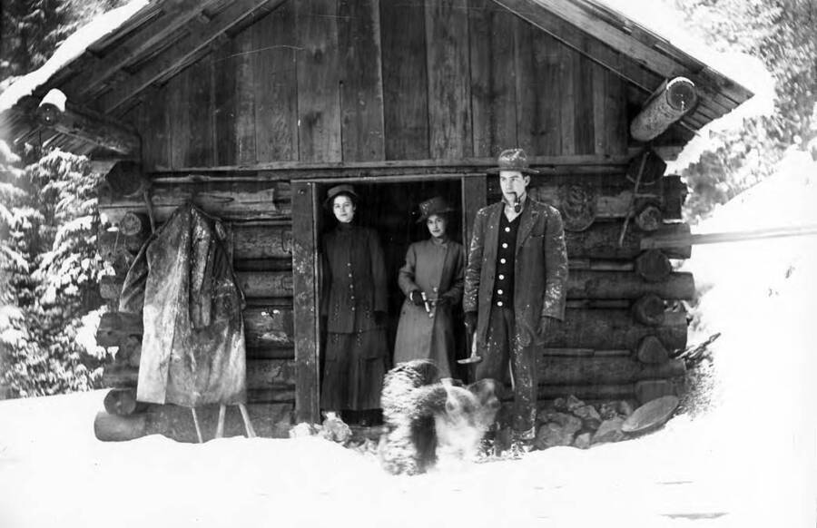 Image shows Fred Richardson and his wife in front of their cabin in Idaho.