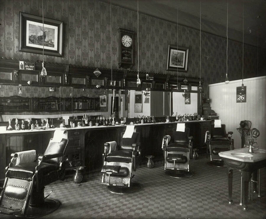 Interior view of the of O.K. Barber Shop in Wallace, Idaho. Spittoons can be seen.