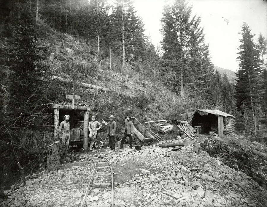 Four miners standing at the portal of the Burke Mining Co. in Burke, Idaho.
