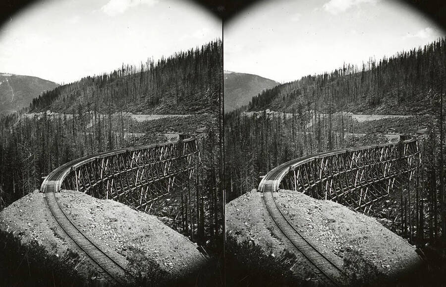 A stereo view of the S Bridge Trestle above Mullan, Idaho. A portion of this trestle was wiped out by a massive snow slide in 1903.