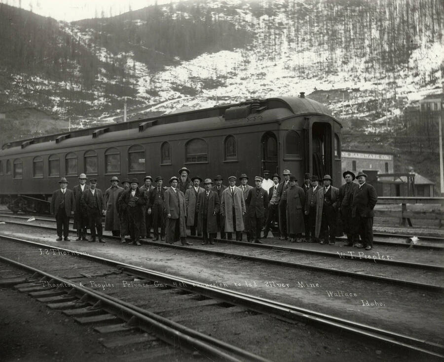 View of the Thornton and Peopler Private Railroad Car. Twenty-three men are standing in front of the car. This was during the fourth excursion to the lead and silver mine. J.S. Thorton can be seen standing on the far left and W.T. Peopler is standing on the far right.