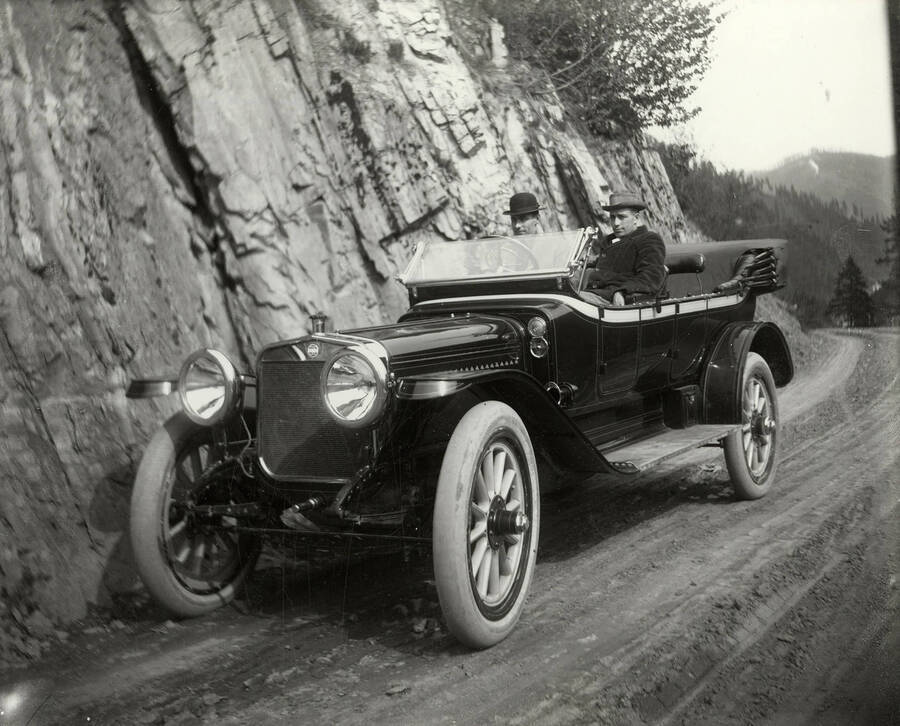 View of a convertible Winton automobile made by Winton Carriage Company in Cleveland, Ohio. Two men can be seen seated in the car.