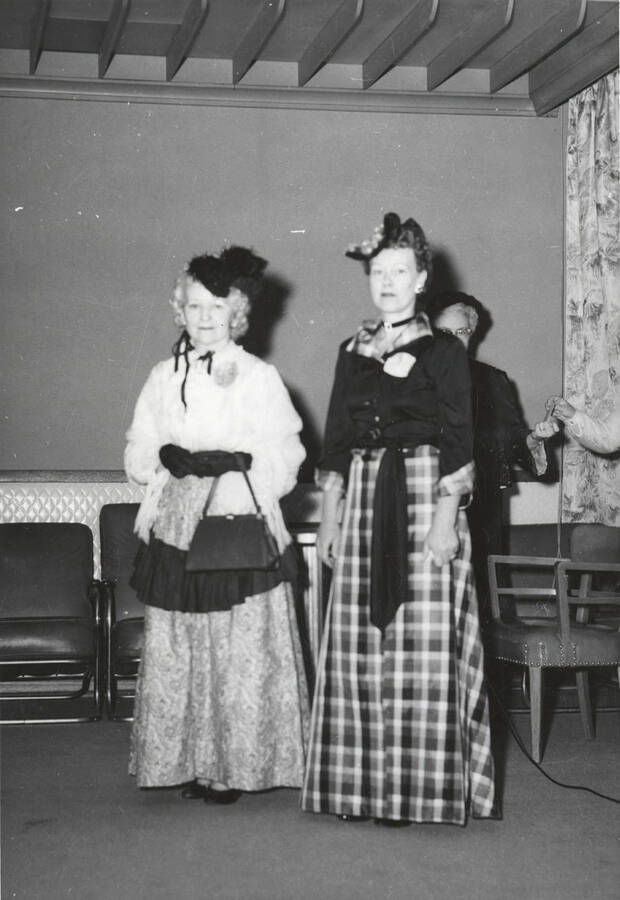 Informal portrait of two women wearing early 20th century dresses to the fashion show at the North Idaho Press Jubilee.