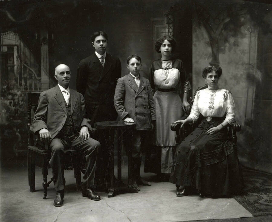 Mrs. Messinger poses for a group photo with her family. The older man and lady are seated, while the children stand in the middle.