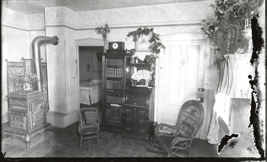 Portrait of the parlor in Barry N. Hillard's home in Murray, Idaho. The negative suffered some degradation before printing, causing the anomalies on the right side of the photograph.