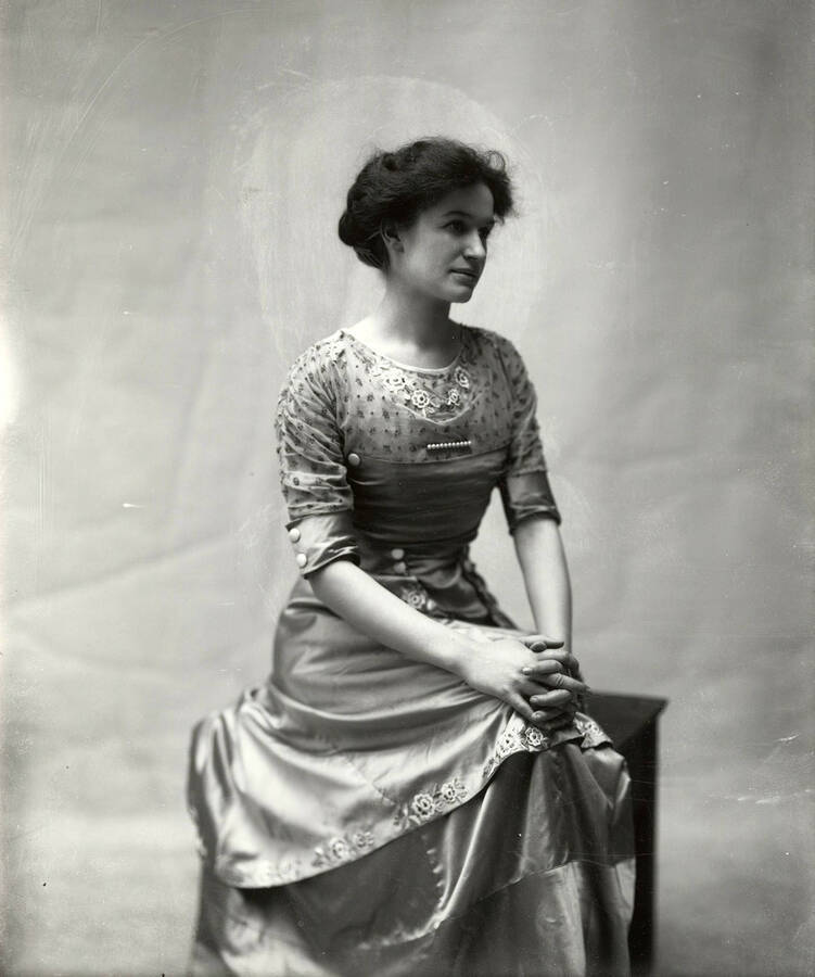 Portrait of Miss LaRue, who is posed seated.