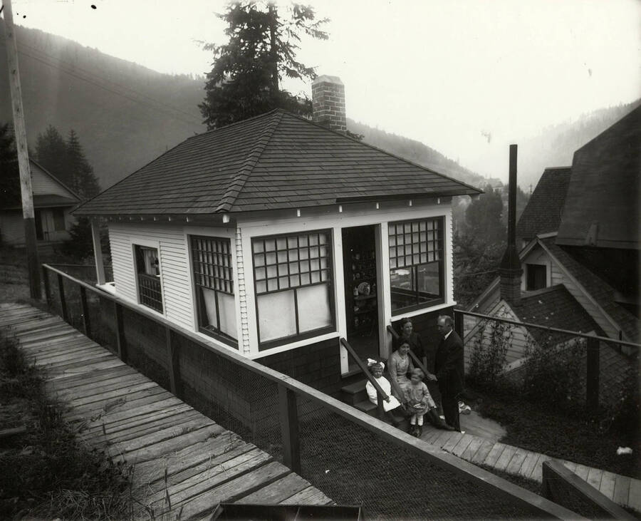 Group photo of the Samuels family on the porch of a house. A man and woman stand with a young girl and boy, while another woman is seated on the steps.