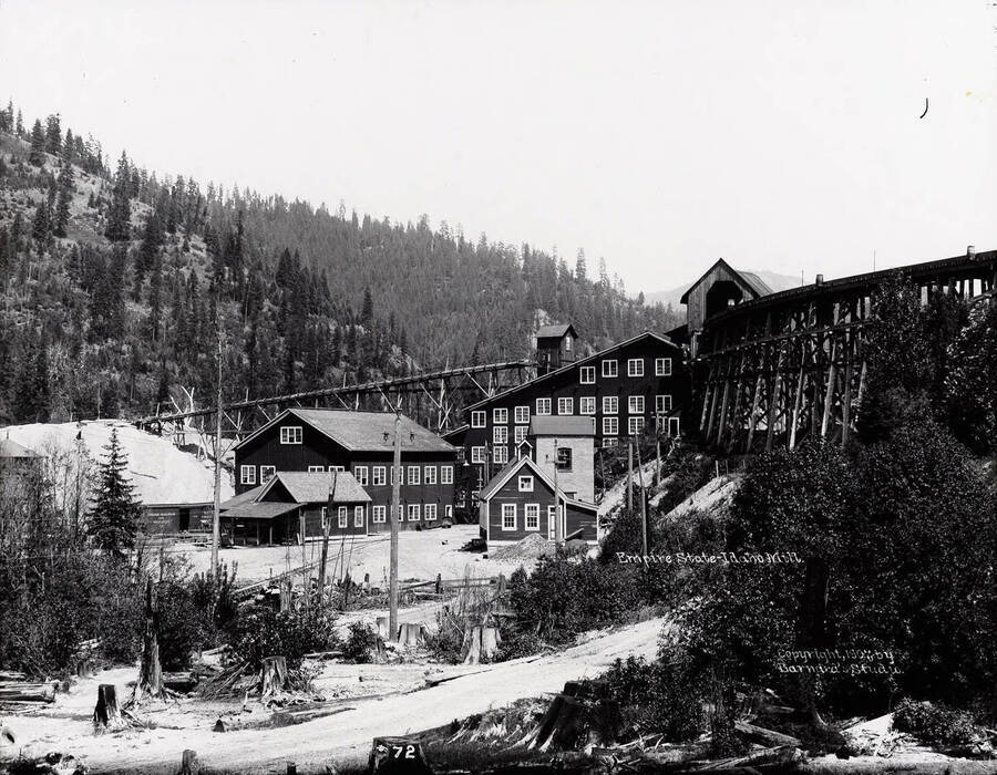 Image of the mill at Empire State Mining and Developing Co., toward the mouth of Government Gulch.  Caption on back: "Located 3 miles west of Kellogg and 3 miles northwest of Wardner. (Sanborn map)."