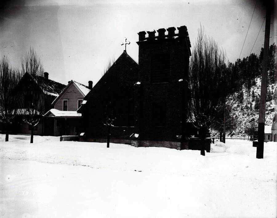 Snow scene of the exterior view of Holy Trinity Episcopal Church in Wallace, Idaho.
