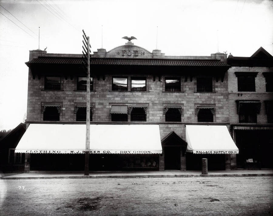 Exterior view of the Eagles block  in May 1906, also shows Wallace Supply Co., W.J. Baker Co., and other offices in Wallace, Idaho.