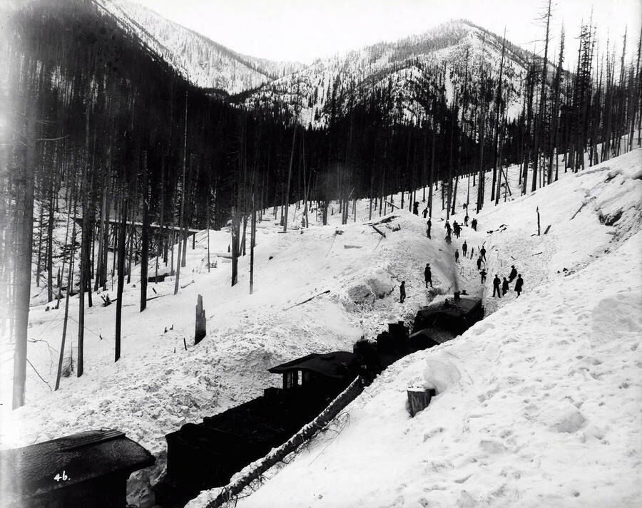 Image of the Coeur d'Alene cut off showing men and N.P. [Northern Pacific] train at work in snow.