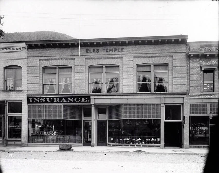 Exterior view of the Elks Temple, Herman J. Rossi Ins., Wallace Light and Walter Co., and Western Union Office in Wallace, Idaho.