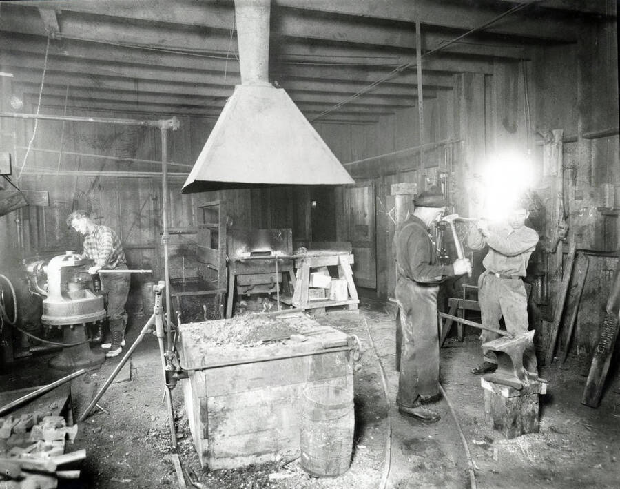 Image shows a men working in a blacksmith shop at the Amazon Dixie Mine in Sildex, Montana, 1923.