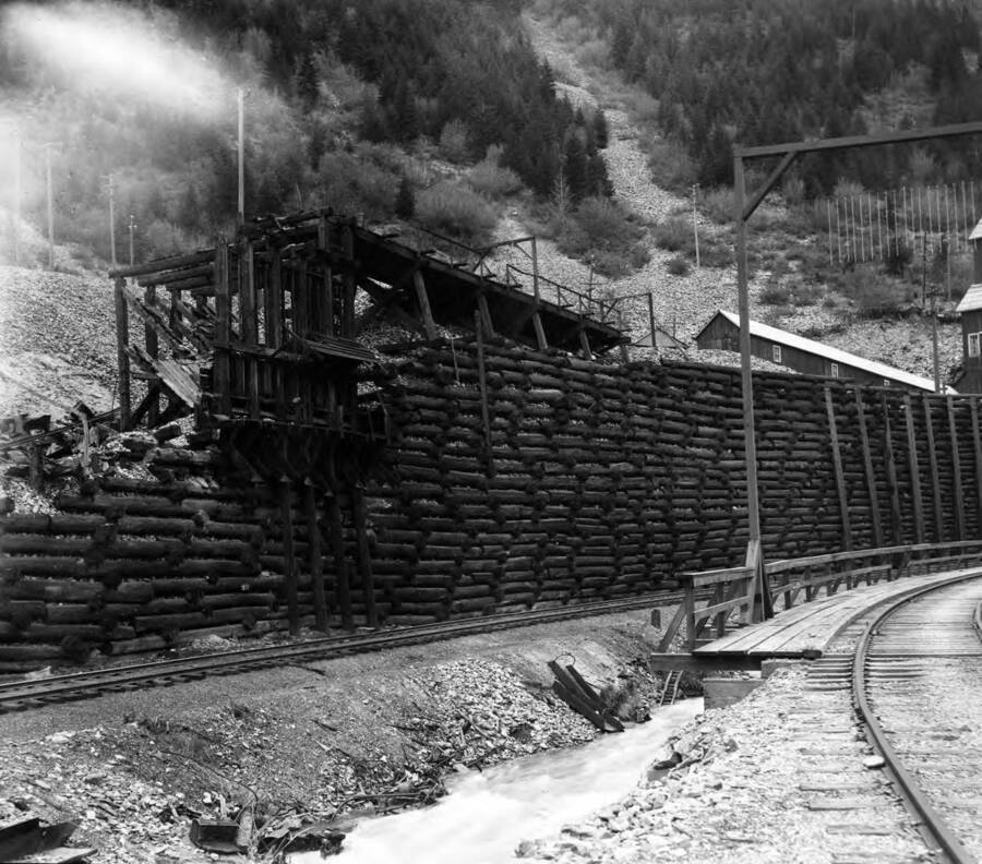 Image shows retaining wall for mine along railroad tracks.