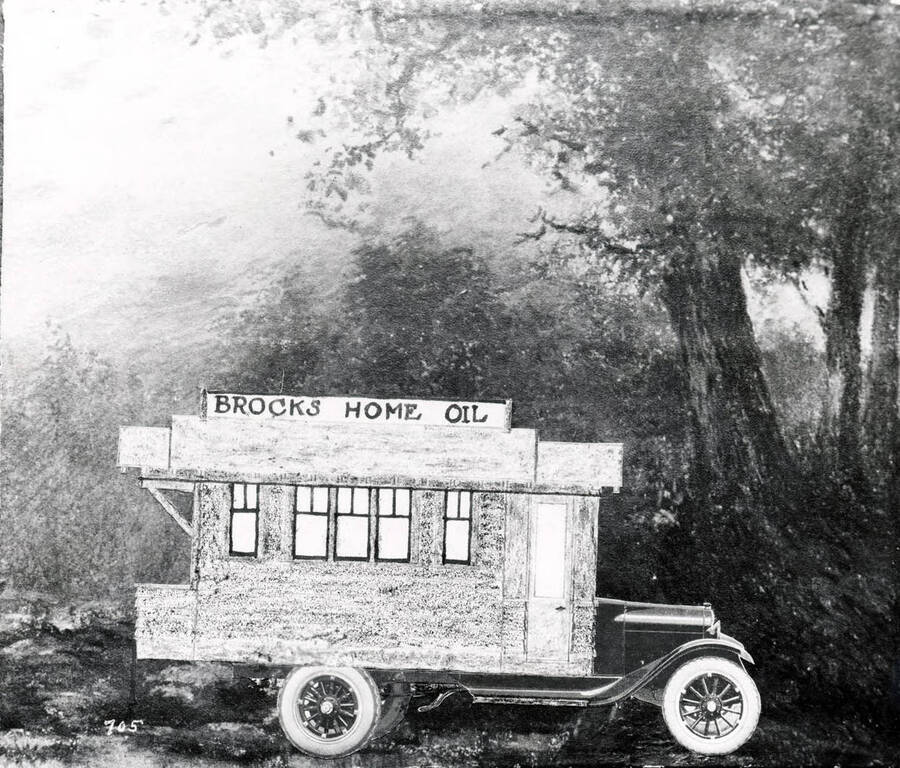 Image is a copy, from T.M. Brock, of an unframed picture of a truck that has a house sketch on it. A sign on top of house says Brocks Home Oil. Trees are in the background of photo (see also 8-o732).