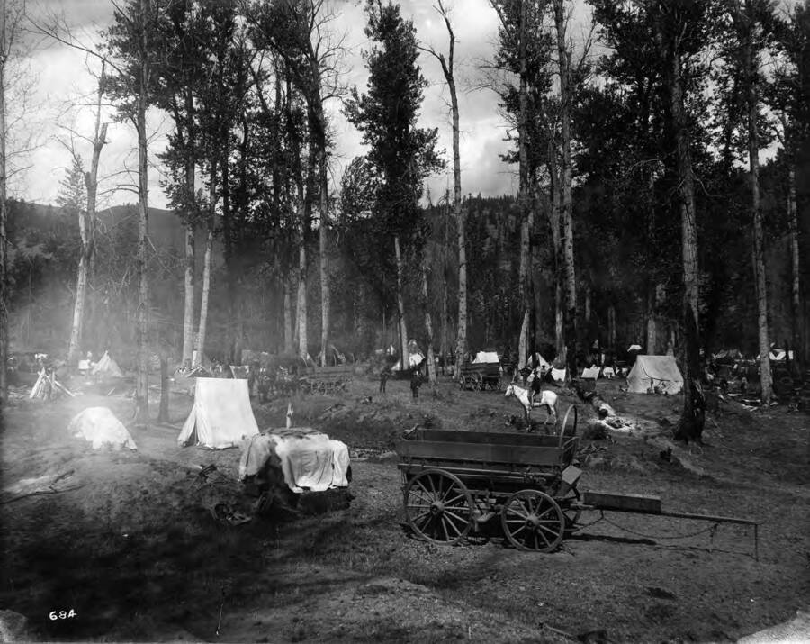 Image shows tents, wagons and horses in Jack Ass Prairie, Milo Gulch outside Kellogg, Idaho.