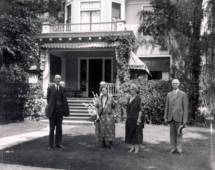Image shows two women and two men standing in the yard of the C.W. Beale house in Wallace, Idaho, 1925.