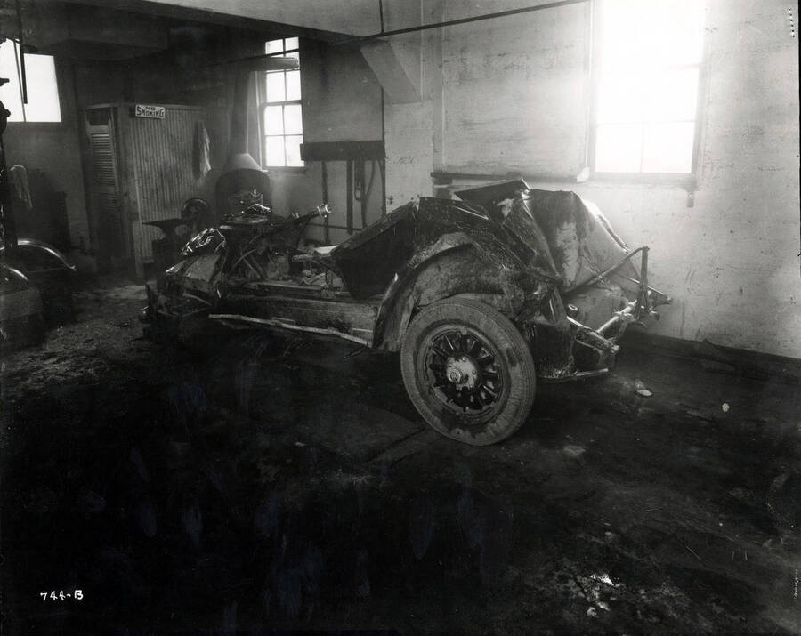 Image shows a wrecked car in the Wallace Garage, Wallace, Idaho, December 1925.
