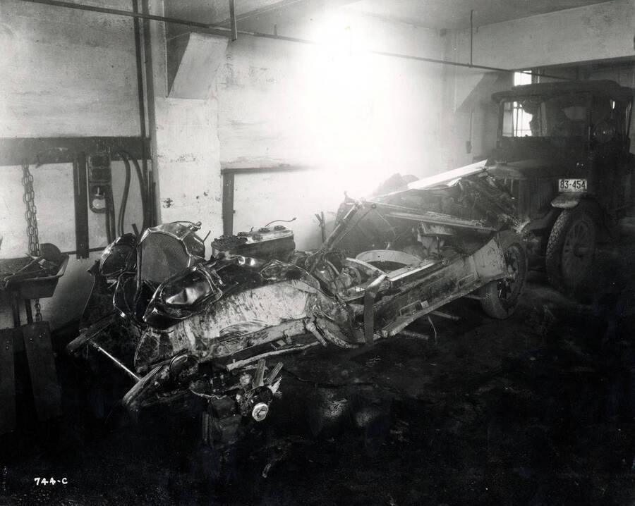Image shows a wrecked car in the Wallace Garage, Wallace, Idaho, December 1925.