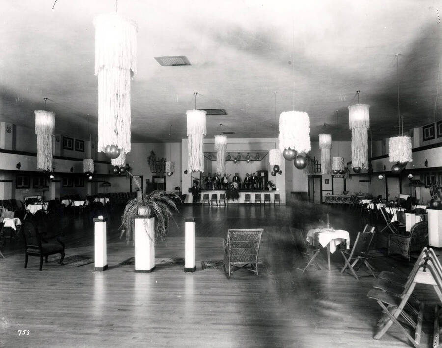 Interior view of Howarth Hall set up for a dinner and dance. A band can be seen on stage. Image taken in Wallace, Idaho, November 1925.