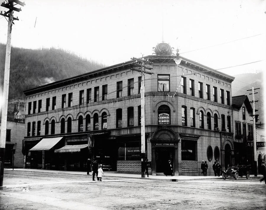 Exterior view of the Wallace National Bank in Wallace, Idaho on the corner of 6th and Cedar.  Caption on front: "6th and Cedar"