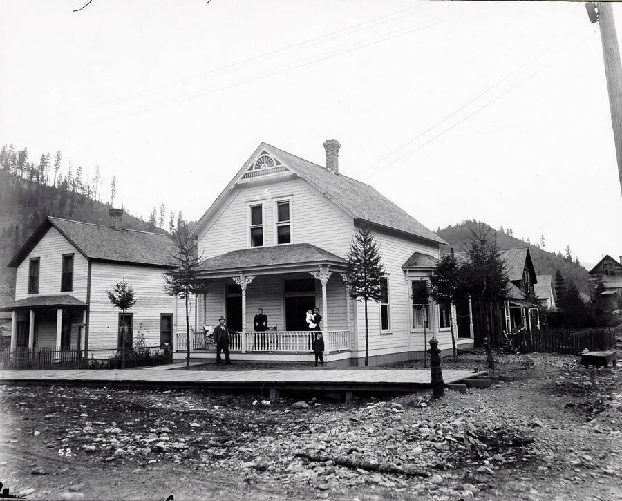 Image shows T.N. Barnard standing at his residence in Wallace, Idaho [1898] with a group of people. Mr. Barnard was a photographer and the owner of Barnard's Studio in Wallace, Idaho.