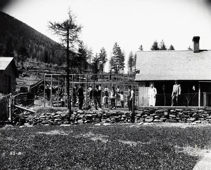 Image of the Coeur d'Alene Powder Co., in Wallace, Idaho; A group of unidentified men are standing around an unfinished structure.