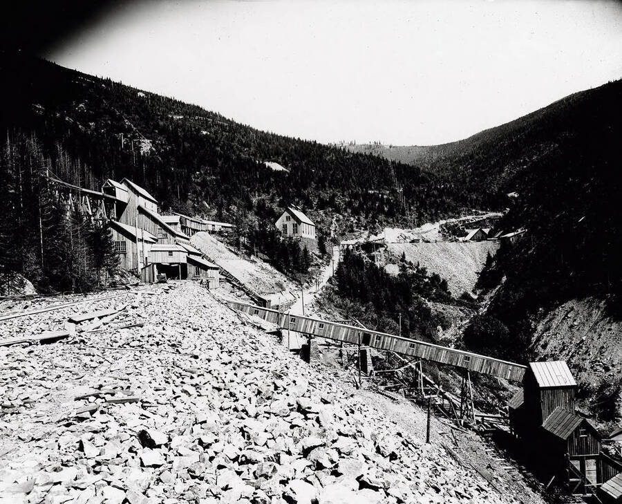 Caption on Back: Hercules #4 - Crushing and Sorting Plant - built right after mill burned down - about 1911. Head of Aerial Tramway, shown lower right. It discharged near N.P. siding in Burke, for loading of sorted crude lead-silver ore. Waste also hand-picked and trimmed to waste dump in foreground.