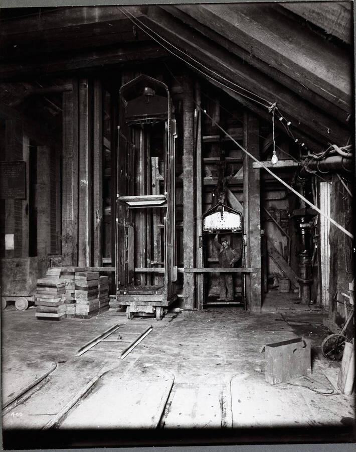 Interior of the mine showing cages or lifts with a man inside